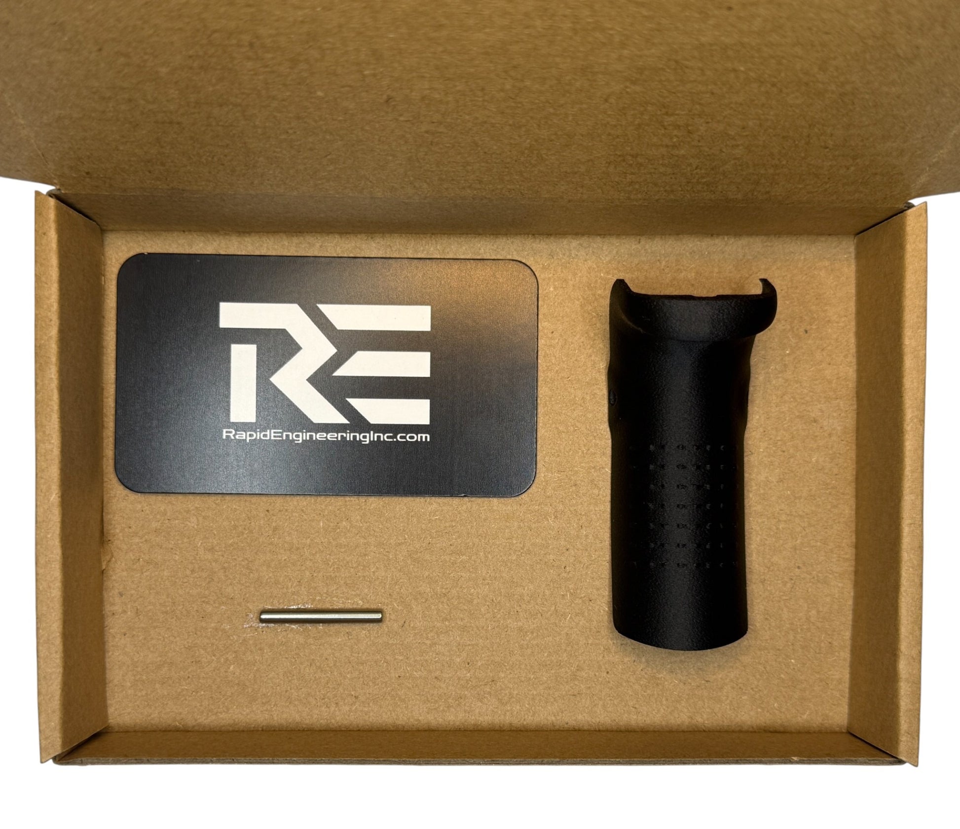 Backstrap kit contents shown in packaging: Rapid Engineering Inc. branded card, Glock-compatible beavertail backstrap, and installation pin arranged inside a cardboard box.