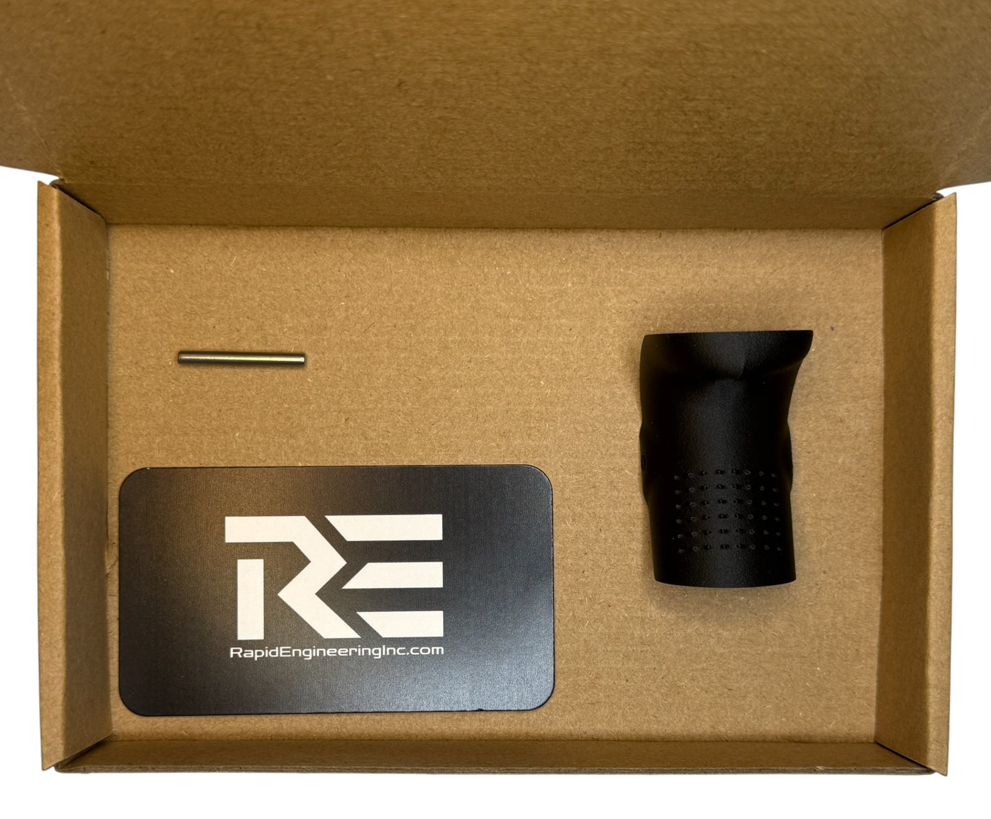 Backstrap kit contents shown in packaging: Rapid Engineering Inc. branded card, Glock-compatible beavertail backstrap, and installation pin arranged inside a cardboard box.